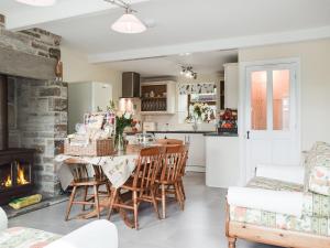 a kitchen with a table and chairs and a fireplace at Shelduck Cottage in Holmfirth