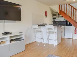 a kitchen with two white chairs and a counter at Bunker - Uk11039 in Carlyon Bay