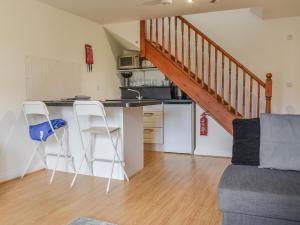 a kitchen with a counter and two chairs in a room at Bunker - Uk11039 in Carlyon Bay