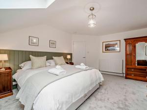 a bedroom with a large white bed with two towels at High Dougarie Farmhouse in Dougarie