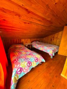 a room with two beds in a wooden cabin at Casa familiar Queule in Queule +3 photos