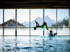 a person jumping into the water in a swimming pool at Landal Brandnertal in Bürserberg