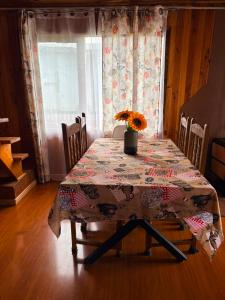 a dining room table with a flowered table cloth on it at Casa familiar Queule in Queule