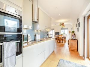 a kitchen with white cabinets and a dining room at Larks Nest in Wortham