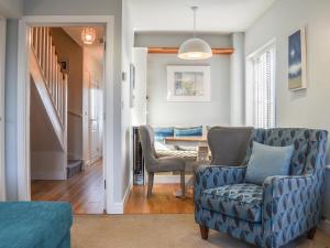 a living room with a blue couch and a table at Coed Faen in Saint Helens