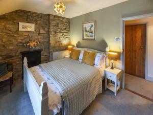 a bedroom with a bed and a stone wall at Summerhill Tanyrhos in Blaenau-Ffestiniog