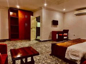a hotel room with a bed and a desk and a chair at Elite Gold Luxury Hotel in Abuja