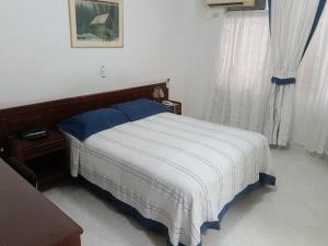 a bedroom with a bed with blue and white sheets at Hotel Lord by Croma in Cúcuta