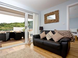 a black leather couch in a living room with a view at Dunlin 1 - The Cove in Brixham