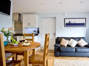 a living room with a table and a couch at Dunlin 1 - The Cove in Brixham