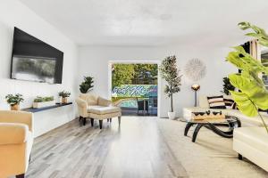 a living room with white furniture and plants at New Casa Eva Turfed Pool 5Br in Hallandale Beach
