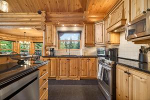 a large kitchen with wooden cabinets and a window at Fiddler Lake Resort - Rabbit 57 in Mille-Isles +23 photos