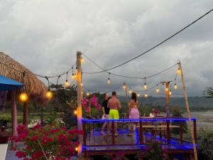 a group of people standing on a bridge with lights at Three Queen Villa and Homestay in Waikabubak