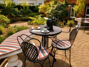 a table with four chairs and a table with a cup on it at Hotel Imperial Rügen in Binz +35 photos