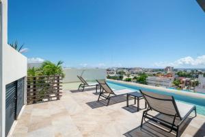 a balcony with chairs and a swimming pool at 2Br Condo W Rooftop Pool & Backyard in Playa del Carmen +18 photos