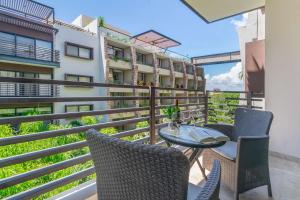 a balcony with a table and chairs and a building at 2Br Condo W Rooftop Pool & Backyard in Playa del Carmen