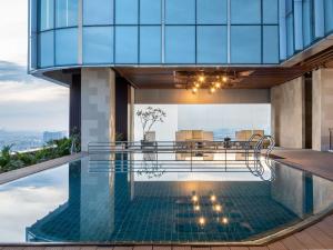 a pool with a table and chairs on a building at Novotel Jakarta Pulo Mas in Jakarta