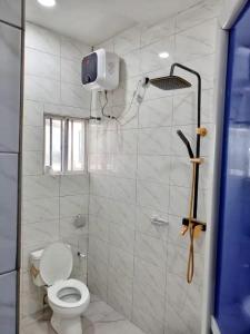 a white bathroom with a toilet and a shower at Naira & Kobo Hotel and suite in Umuahia