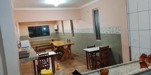 a kitchen and dining room with a table and chairs at Hotel 3 Reis in Guia Lopes da Laguna