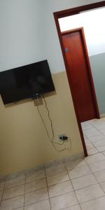 a flat screen tv hanging on the corner of a wall at Hotel 3 Reis in Guia Lopes da Laguna