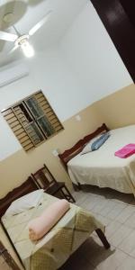 a hotel room with two beds and a window at Hotel 3 Reis in Guia Lopes da Laguna