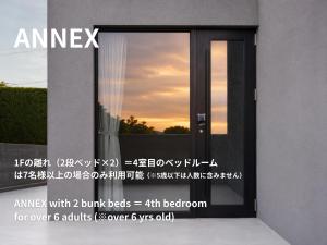 a glass door with a sunset in the background at THE THIRD PLACE tatéyama 楼 in Tateyama