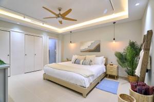 a bedroom with a bed and a ceiling fan at Marbellaluxessence Beachfrontpool11Thfloor in Villas del Mar +62 photos