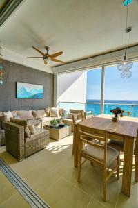 a living room with a table and a view of the ocean at Marbellaluxessence Beachfrontpool11Thfloor in Villas del Mar