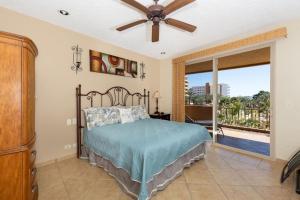 a bedroom with a bed with a ceiling fan and a balcony at Sandy Beach Rocky Point Bella Sirena 203-E in Puerto Peñasco +65 photos