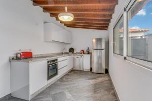 a kitchen with white cabinets and a large window at Villa Winter Apt 1 in Funchal +9 photos