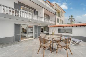 a patio with a table and chairs in front of a house at Villa Winter Apt 1 in Funchal