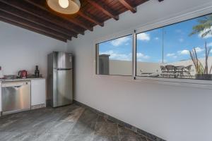 a kitchen with a refrigerator and a large window at Villa Winter Apt 1 in Funchal