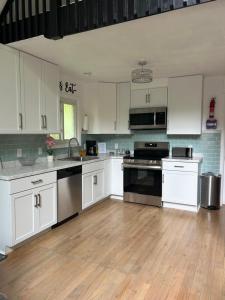 a kitchen with white cabinets and black appliances at The Emerald Cabin in Tobyhanna
