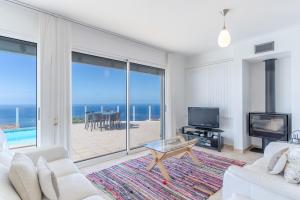 a living room with a view of the ocean at Villa Eldomar Heated Pool in Estreito da Calheta