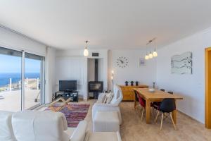 a living room with a white couch and a table at Villa Eldomar Heated Pool in Estreito da Calheta