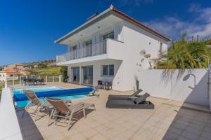 a villa with a swimming pool and a house at Villa Eldomar Heated Pool in Estreito da Calheta