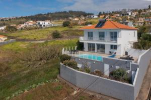 an aerial view of a house with a swimming pool at Villa Eldomar Heated Pool in Estreito da Calheta