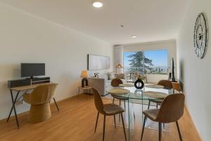 ein Wohnzimmer mit Esstisch und Stühlen in der Unterkunft Sunflower Ocean View Apartment With Pool & Parking in Caniço + 13 Fotos