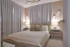 a bedroom with a large bed with white curtains at The-Comfty-Spot Experience Sd Wifi in Santo Domingo