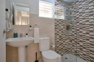 a bathroom with a toilet and a sink and a mirror at The-Comfty-Spot Experience Sd Wifi in Santo Domingo +41 photos