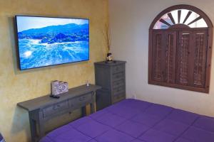 a bedroom with a bed and a dresser and a window at Loft with rooftop deck in the Malecon - Unit #206 in Puerto Peñasco