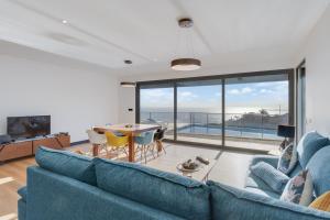 a living room with a blue couch and a table at Casa Mozart Ii Sea View, Pool & Sunny Retreat in Estreito da Calheta
