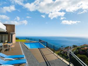 a balcony with a swimming pool and the ocean at Casa Mozart Ii Sea View, Pool & Sunny Retreat in Estreito da Calheta