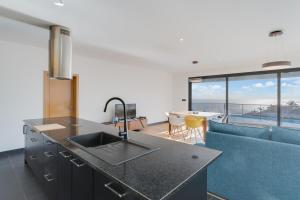 a kitchen with a sink and a living room at Casa Mozart Ii Sea View, Pool & Sunny Retreat in Estreito da Calheta