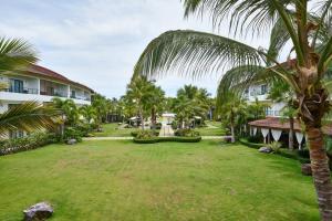 a large yard in front of a resort with palm trees at Sublimeluxcondo Terrenas Jaccuzibeachfront in Las Terrenas