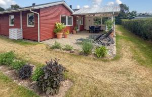 a backyard with a red house with a patio at Gorgeous Home In Haderslev With Wifi in Haderslev +15 photos