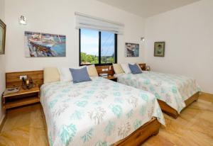 a bedroom with two beds and a window at Beach & Mountain Villaterrenaspoolbbq6Br in Las Terrenas +92 photos