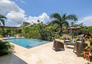 a swimming pool with chairs next to a resort at Beach & Mountain Villaterrenaspoolbbq6Br in Las Terrenas