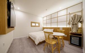 a bedroom with a bed and a table and chairs at Ryokan Hotel The Red Dragonfly in Incheon +6 photos