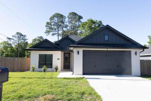 a house with a black roof and a garage at Pensacola Florida in Pensacola